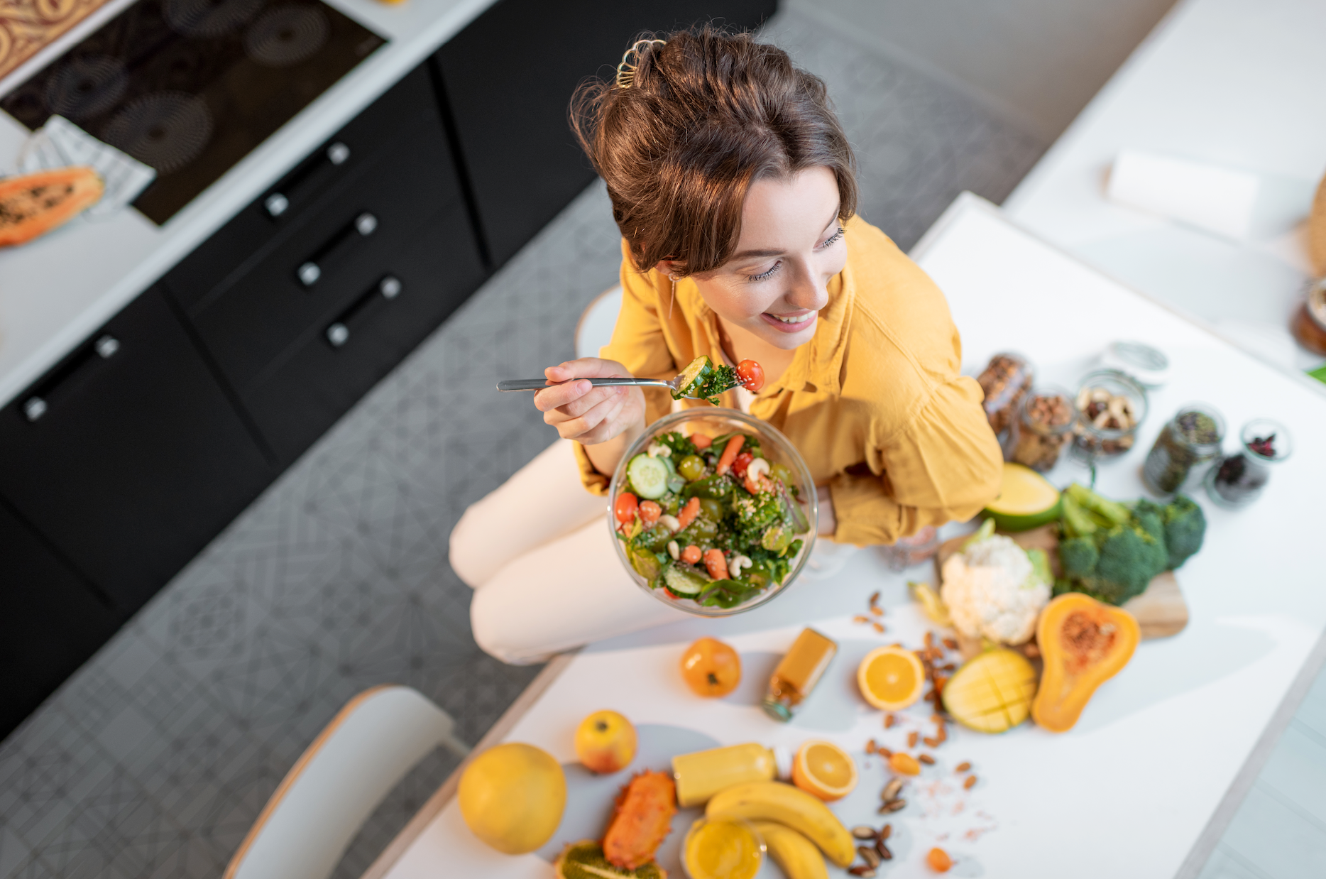 Smiling woman enjoying healthy salad at home