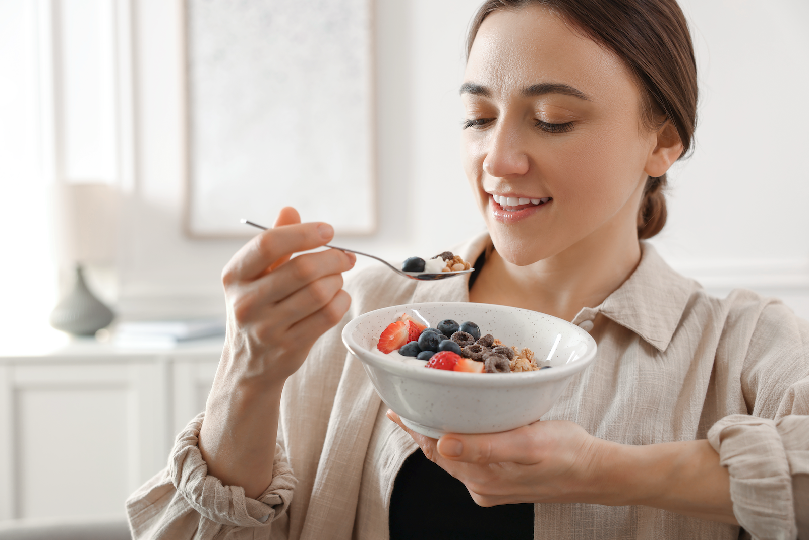 Woman eating healthy breakfast bowl