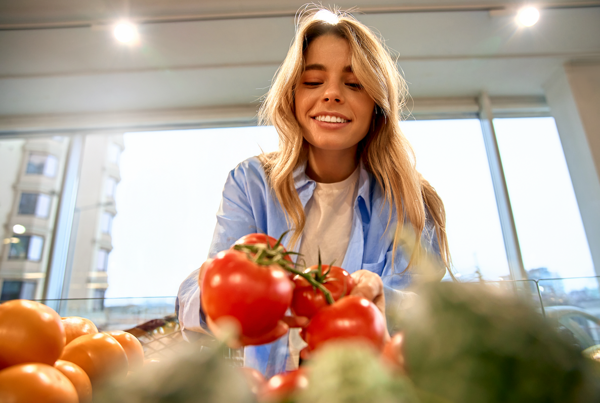 Smiling woman picking fresh tomatoes