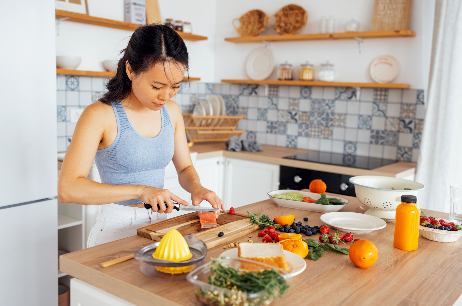 Woman cutting fruit for healthy breakfast at home